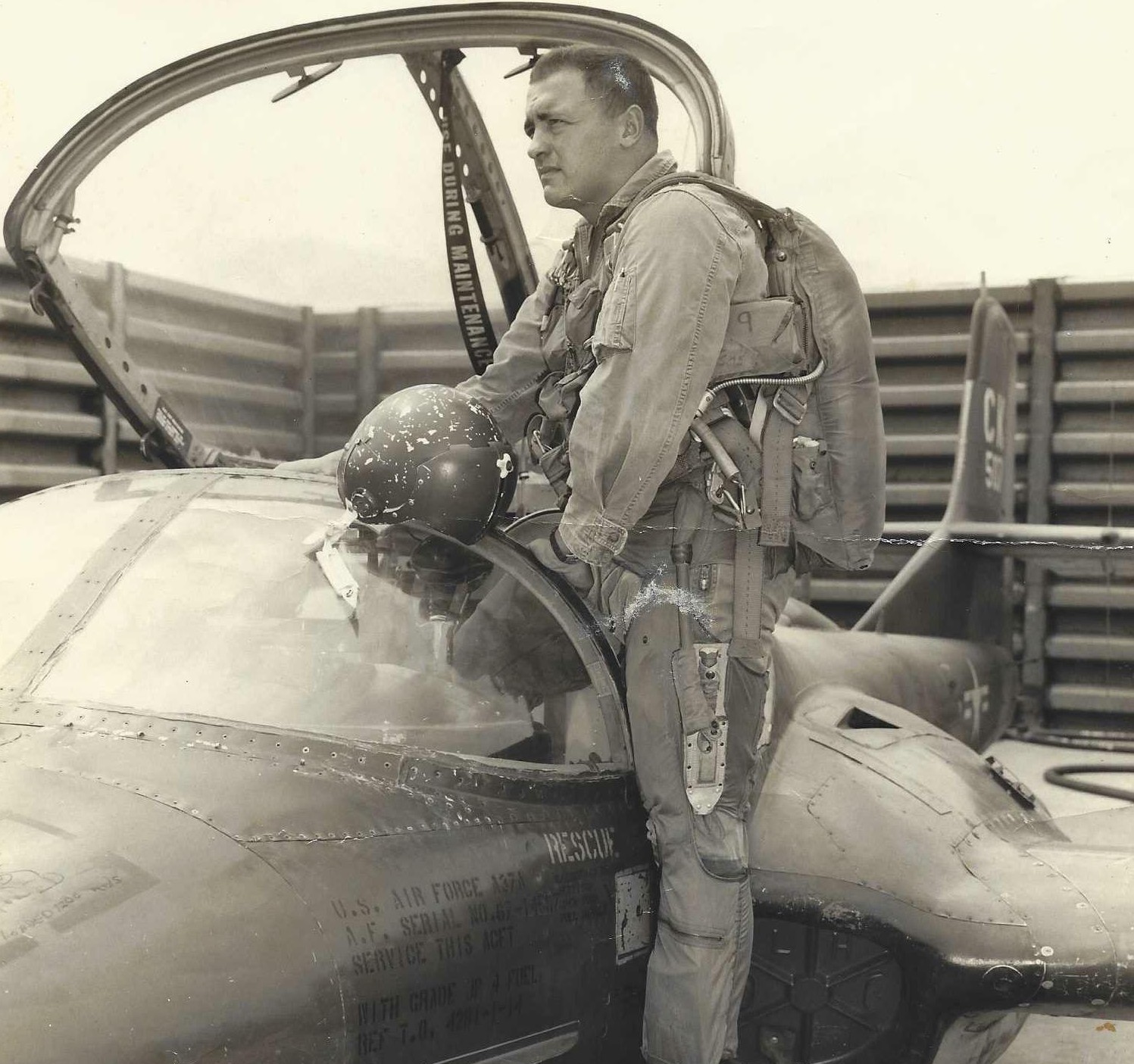 Colonel Richard T. Ryer in flight gear beside an A-37 Dragonfly cockpit